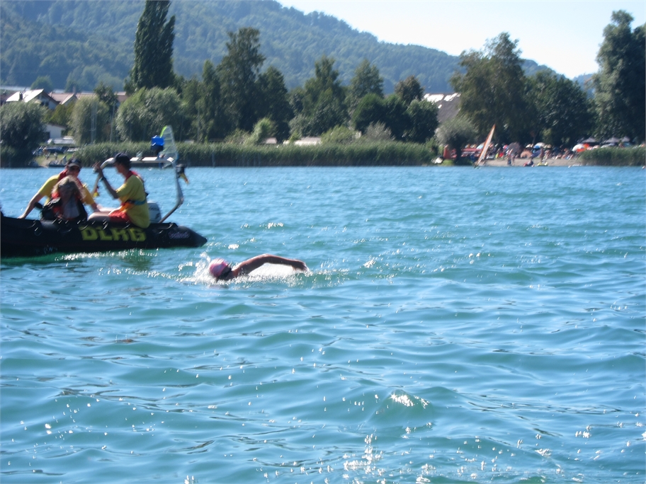 Kirsten Seidel swimming beside a support boat on Lake Constance.